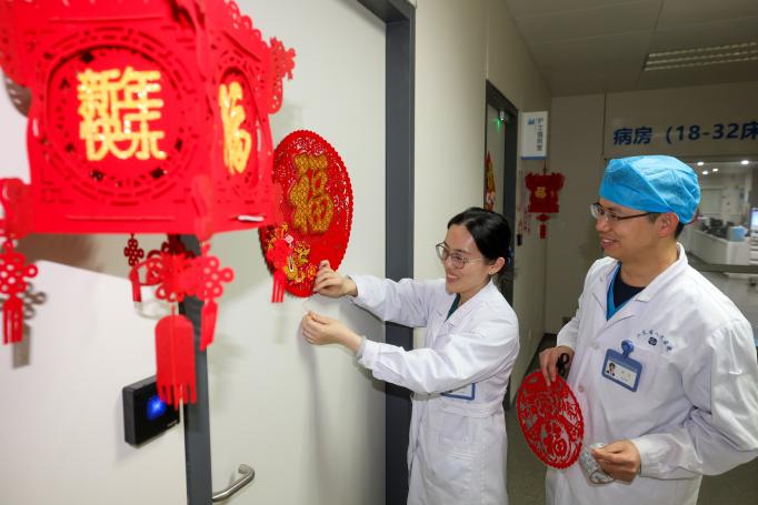 2025年1月28日，在江苏省人民医院，医护人员正在为重症监护室值班室贴福字。