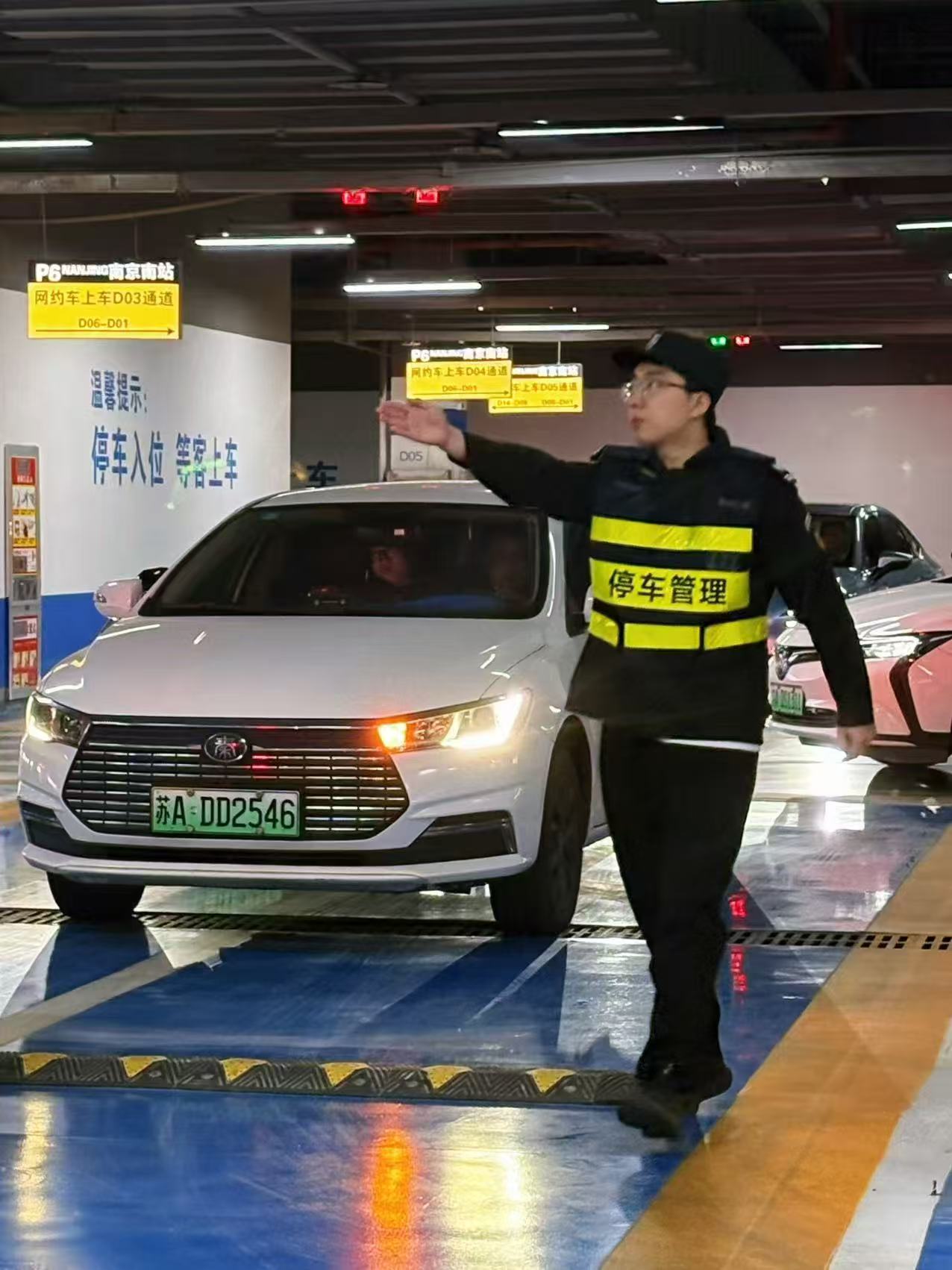 工作人员引导网约车入位等候打车人。