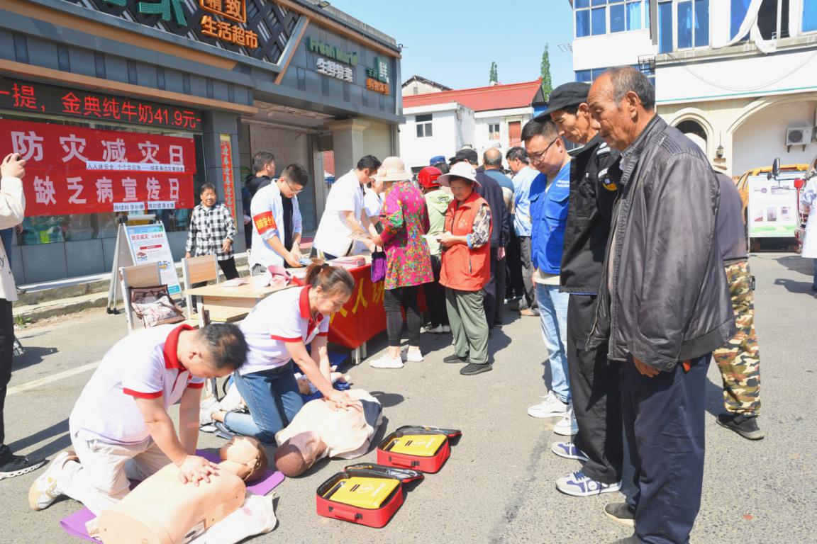 图为溧水区红十字会持证救护员和晶桥镇中心卫生院医护人员利用人工模拟器械向居民演示了心肺复苏术、人工呼吸法、创伤止血及包扎法等紧急救护技术