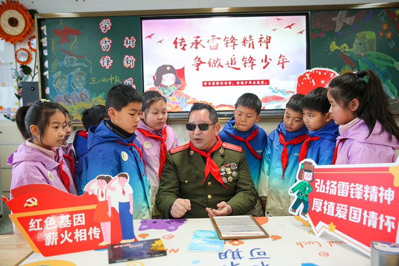 2025年3月3日,江苏南通如皋市安定小学里,伤残军人许波银在思政小课堂上向学生讲述雷锋故事。