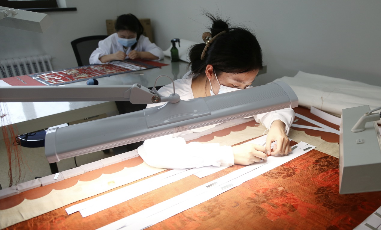 “青春华章·重走西北角”采访团探秘甘肃省博物馆:千年珍宝诉说丝路辉煌_fororder_修复人员正在对纸质文物进行修复