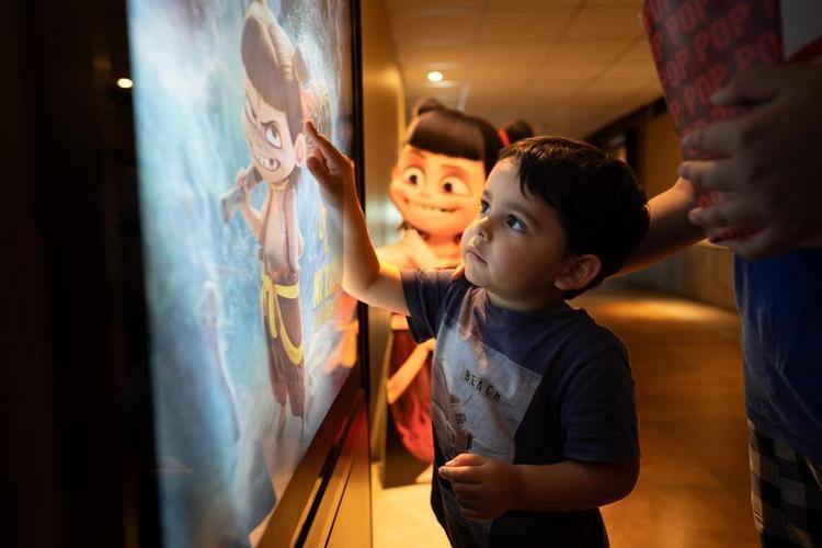 A boy points at a poster for the premiere of Chinese animated film "Ne Zha 2" in a cinema in Buenos Aires, Argentina, on Oct. 2, 2025. (Photo by Martin Zabala/Xinhua)