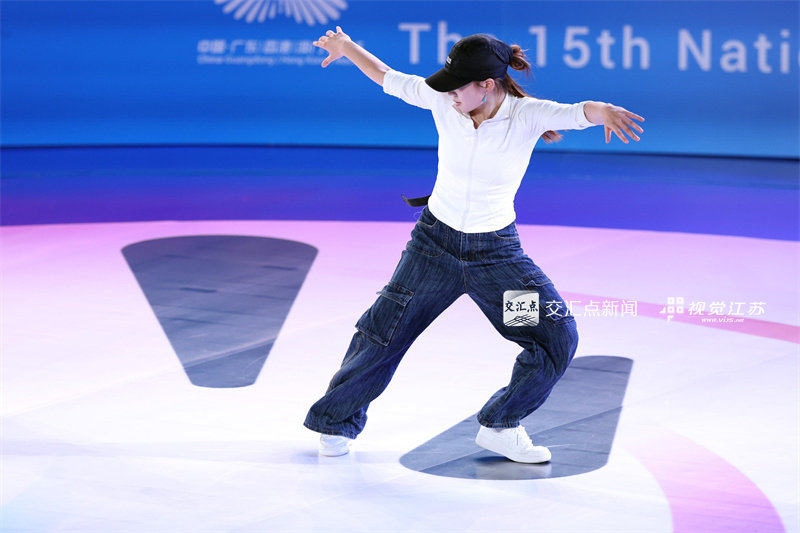11月18日，第十五届全运会霹雳舞项目在广州体育学院亚运馆火热开赛。来自全国各地的顶尖舞者齐聚广州，以力与美的融合展现霹雳舞的激情与个性魅力，上演活力四射的青春对决。图为江苏选手丁静慧在比赛中。新华日报·交汇点记者 万程鹏 摄