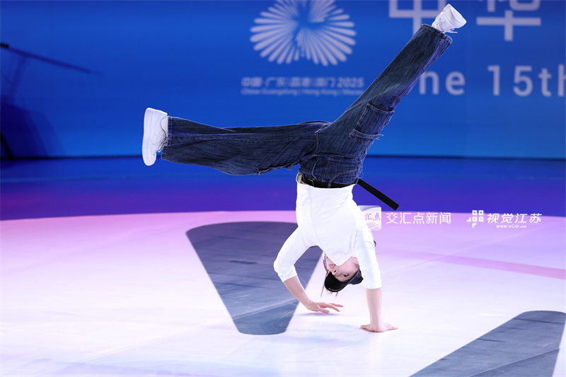 11月18日，第十五届全运会霹雳舞项目在广州体育学院亚运馆火热开赛。来自全国各地的顶尖舞者齐聚广州，以力与美的融合展现霹雳舞的激情与个性魅力，上演活力四射的青春对决。图为江苏选手丁静慧在比赛中。新华日报·交汇点记者 万程鹏 摄