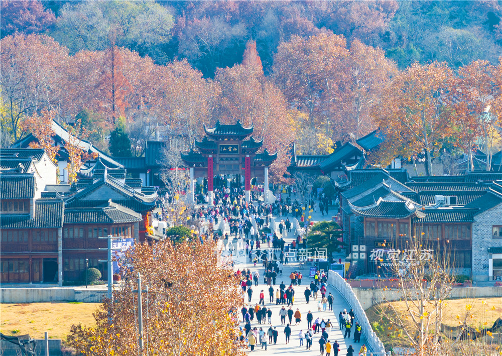 12月14日，天气晴好，南京栖霞山景区游客如织，迎来赏枫最佳观赏期。当下，漫山红叶正处于最饱满绚烂的阶段，鸡爪槭嫣红、枫香橙黄、乌桕深紫，层层叠染，犹如一幅浓墨重彩的天然油画，人们漫步于红叶掩映的山径，纷纷驻足拍照，尽情享受这一年一度的视觉盛宴。新华日报·交汇点记者 邵丹 摄