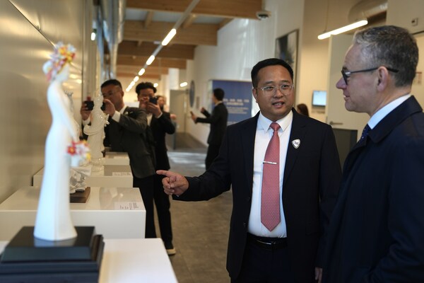Photo taken on Feb. 24 shows Fang Junqin, Party Chief of Dehua County in southeast China's Fujian Province introducing Dehua white porcelain exhibits to foreigners in Palais des Nations in Geneva, Switzerland.