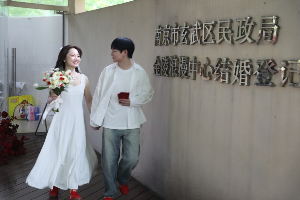 5月20日，天空飘着淅沥小雨，南京 “金陵浪漫中心”婚姻登记处，众多新人冒雨前来领证，画面温馨甜蜜，为雨中的金陵城平添几分浪漫气息。
“520”因谐音“我爱你”，已成为众多适婚青年眼中的“良辰吉日”。 据悉，有超2800对新人选择5月20日这天在南京领证。 
新华日报•交汇点记者 聂伟 通讯员 徐福庚